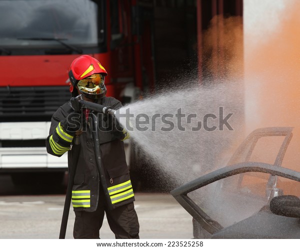 brave firefighter with helmet off the car burned\
with the foam