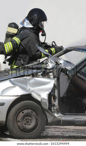 brave firefighter trying to save injured people\
inside a crashed car