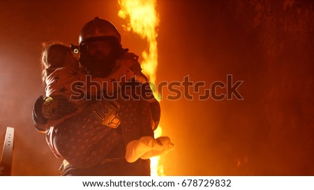 Brave Fireman Holds Saved Girl in His Arms in a Burning Building with open fire in the Background.