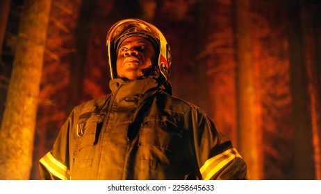 Brave Handsome Young African American Firefighter in Safety Uniform and a Helmet Looking Around the Forest During a Wildfire. Professional Squad Leader Assessing the Dangerous Situation. - Shutterstock ID 2258645633