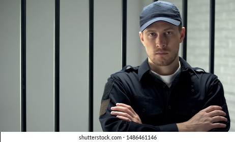 Brave Jail Guard Looking At Camera Standing Near Cell, Dangerous Occupation