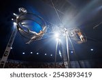 Brave male acrobats in the rotating wheel of death perform under the dome of the circus