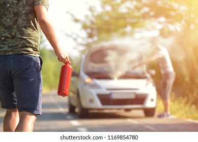 Brave Man With Fire Extinguisher Going To A Car Incident On The Road With Smoke On The Engine