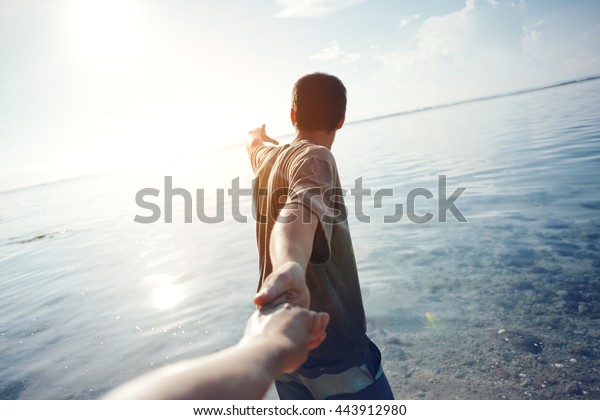 Brave man\
guiding traveling woman through the\
water