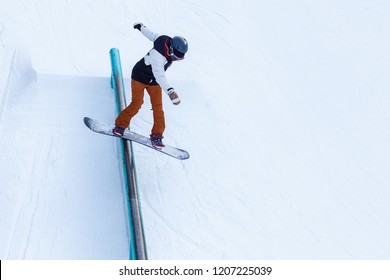 A Brave Man Performs A Rail Slide On Snowboard