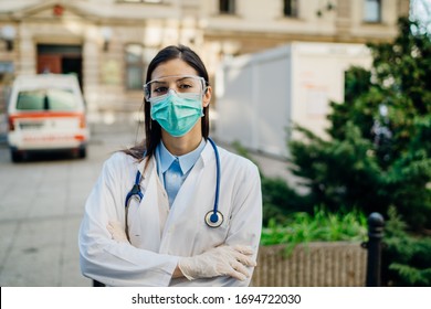 Brave Optimistic Paramedic In The Front Lines,working In A Isolation Hospital Facility With Infected Patients.Covid-19 Emergency Room Triage Doctor With Protective Glasses / Mask.Fighting Coronavirus