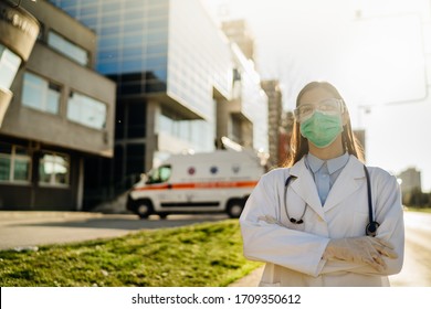 Brave Optimistic Paramedic In The Front Lines,working In A Isolation Hospital Facility With Infected Patients.Covid-19 Emergency Room Triage Doctor With Protective Glasses / Mask.Fighting Coronavirus