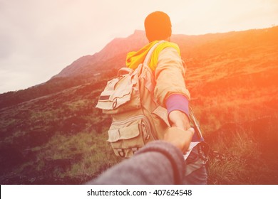 Brave and romantic traveler guiding woman to the mountain in the wild (intentional sun glare and vintage color) - Shutterstock ID 407624548