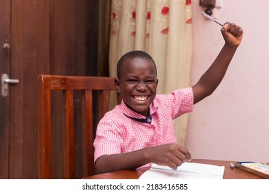 Brave Young African School Boy Happily Raising One Arm Finishing School Work