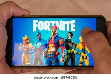 Brazil - January 18, 2021: Hand Holding Cell Phone With Fortnite Online Multiplayer Video Game, For Smartphone. Selective Focus.