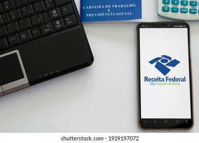 Brazil - March 4, 2021: cell phone with income tax return app, computer, calculator and Brazilian work card. Tax payment concept. space to text. IRS. irpf22 