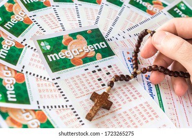 Brazil - May 2020: Various Mega Sena Tickets (National Lottery Of Brazil) And A Religious Cross Over It - Lottery Brand By Caixa Economica Brazilian Federal Bank