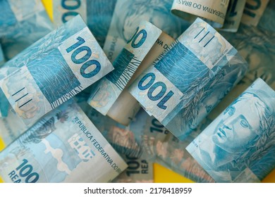 Brazil money piled up - detail in hundred reais bills spread on the surface - Shutterstock ID 2178418959