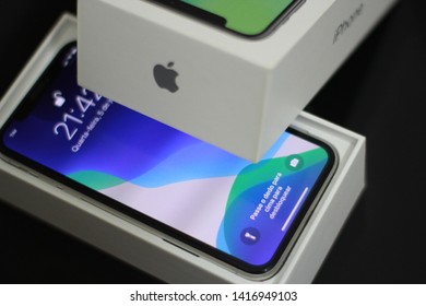 BRAZIL, MS, CAMPO GRANDE - JUNE 05, 2019: A Box Of A New IPhone X Being Opened With Wallpaper Of The New IOS 13