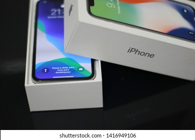 BRAZIL, MS, CAMPO GRANDE - JUNE 05, 2019: A Box Of A New IPhone X Being Opened With Wallpaper Of The New IOS 13