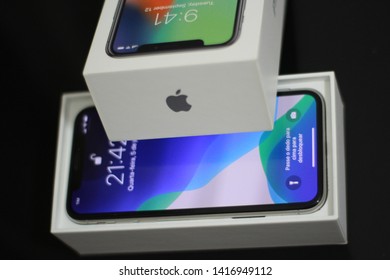 BRAZIL, MS, CAMPO GRANDE - JUNE 05, 2019: A Box Of A New IPhone X Being Opened With Wallpaper Of The New IOS 13