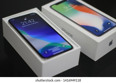 BRAZIL, MS, CAMPO GRANDE - JUNE 05, 2019: A Box Of A New IPhone X Being Opened With Wallpaper Of The New IOS 13