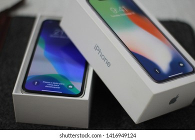 BRAZIL, MS, CAMPO GRANDE - JUNE 05, 2019: A Box Of A New IPhone X Being Opened With Wallpaper Of The New IOS 13