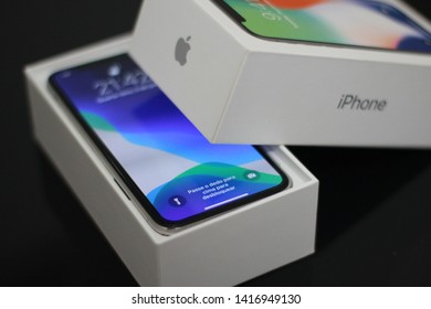 BRAZIL, MS, CAMPO GRANDE - JUNE 05, 2019: A Box Of A New IPhone X Being Opened With Wallpaper Of The New IOS 13