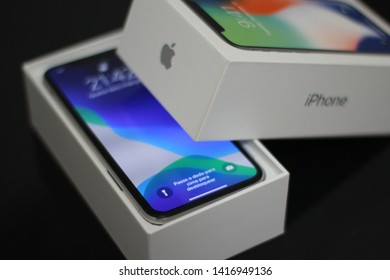 BRAZIL, MS, CAMPO GRANDE - JUNE 05, 2019: A Box Of A New IPhone X Being Opened With Wallpaper Of The New IOS 13