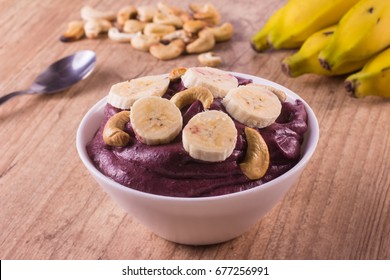 Brazilian Acai Into A Bowl Over A Wooden Table