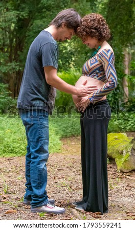 Brazilian affectionate pregnant couple touching stomach 