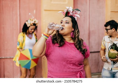 Brazilian Carnival. Person drinking water during carnival block on the street - Shutterstock ID 2105784275