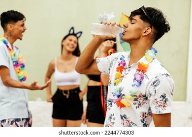 Brazilian Carnival. Person drinking water during carnival block on the street - Shutterstock ID 2244774303