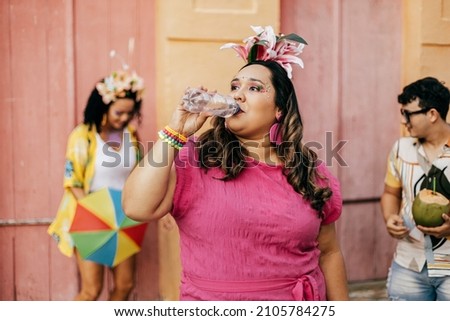 Brazilian Carnival. Person drinking water during carnival block on the street