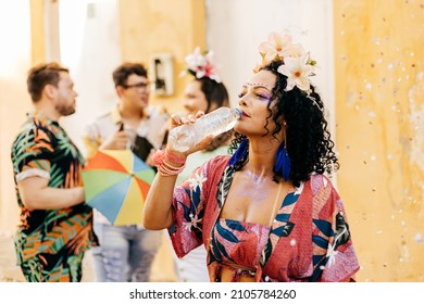 Brazilian Carnival. Woman drinking water during carnival block on the street - Shutterstock ID 2105784260