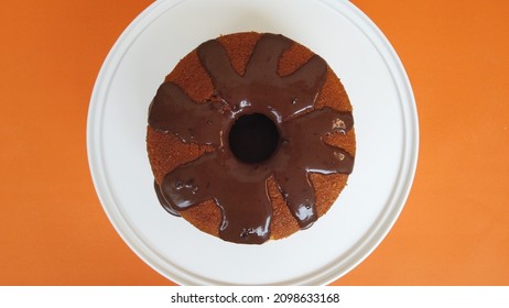 Brazilian Carrot Cake With Chocolate Topping On Orange Background Viewed From Above