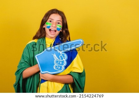 Brazilian caucasian child soccer fan pointing to the side, advertisement, promotion, advertisement. World Cup. Olympics.