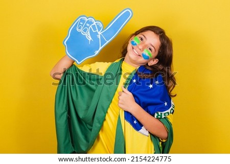 brazilian caucasian child soccer fan with foam finger celebrating and partying. World Cup. Olympics.