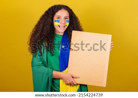 Brazilian caucasian girl soccer fan holding sign for announcement, text, advertisement. World Cup. Olympics.