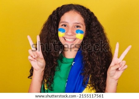 Brazilian, Caucasian girl, soccer fan, close-up photo, expression of peace and love, fingers raised, happy pose for photo. World Cup. Olympics.