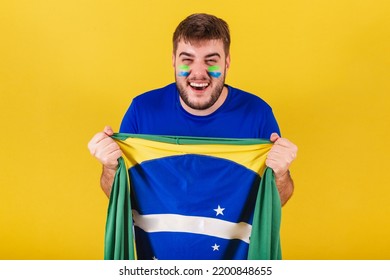 Brazilian Caucasian Man, Soccer Fan From Brazil, Cheering In Joy, Holding Brazil Flag.