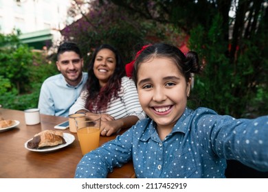 brazilian child taking selfie with mobile in table outside