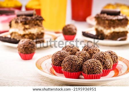 Brazilian children's party candy, brigadeiro, truffle or chocolate candy made with condensed milk and granulated chocolate, children's party candy, , sweets and birthday cakes in the background
