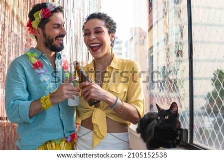 Brazilian couple celebrating Carnival at home. Man and woman toasting during Carnaval in Brazil.