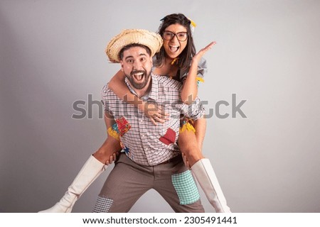 Brazilian couple dressed in festa junina clothes, feast of São João. playing together.