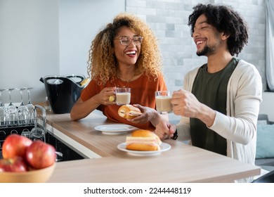 Brazilian couple eat snack and laugh at home - Powered by Shutterstock