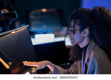 Brazilian cybersecurity engineer explaining complex firewall configurations and data protection strategies to a team member in a digital bunker.