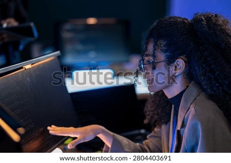 Brazilian cybersecurity engineer explaining complex firewall configurations and data protection strategies to a team member in a digital bunker.