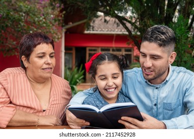 brazilian dad reading book for child outside in the garden - Powered by Shutterstock