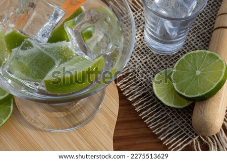 brazilian drink (caipirinha) on the table with ingredients in a sunny day