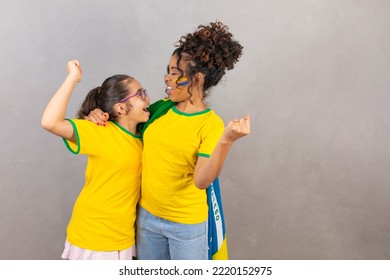 Brazilian family fans of Brazil. Afro mother and daughter with brazilian clothes. Mother and daughter with clenched fists celebrating the victory of Brazil, - Powered by Shutterstock