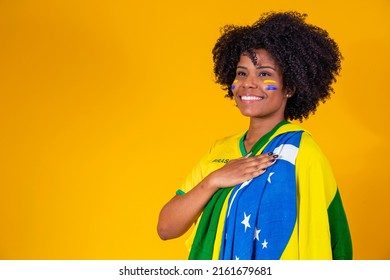 Brazilian fan. wearing Brazilian flag in a portrait, Brazilian fan celebrating football or soccer game on yellow background. Colors of Brazil.World Cup - Shutterstock ID 2161679681