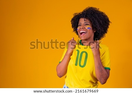 Brazilian fan. wearing Brazilian flag in a portrait, Brazilian fan celebrating football or soccer game on yellow background. Colors of Brazil.World Cup