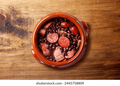 Brazilian feijoada, traditional food from Brazil cuisine, on ceramic casserole bowl, over rustic wooden table. top view - Powered by Shutterstock