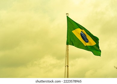 Brazilian flag flying on an iron bar. National symbol. Pavilion. Symbol of the Federative Republic of Brazil. coat of arms. National identity. Green and yellow flag. - Powered by Shutterstock